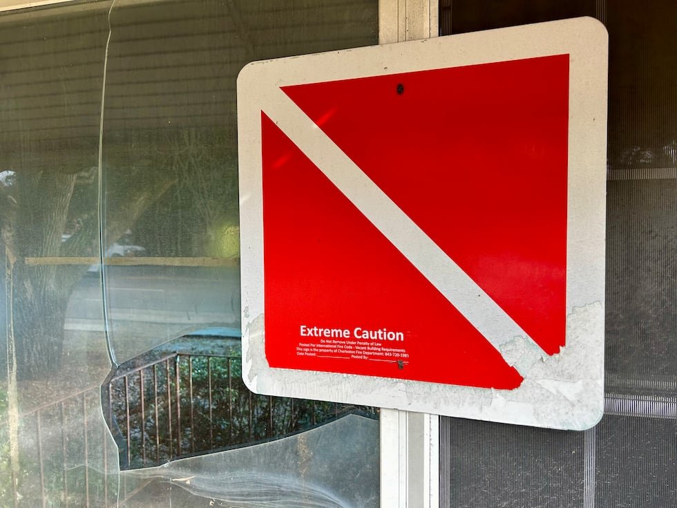 A placard from the city of Charleston sits in front of a vacant property owned by Dr. James...