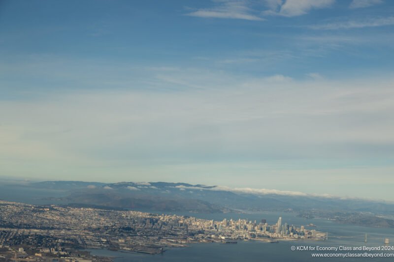 a cityscape with water and mountains in the background