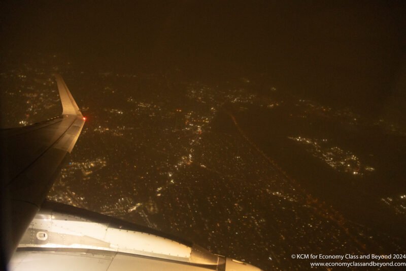 an airplane wing and a city at night