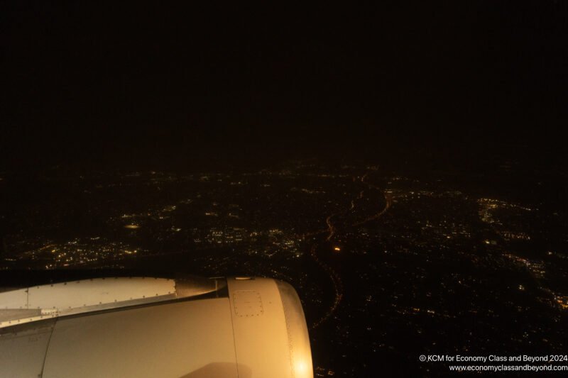 an airplane wing and a city at night