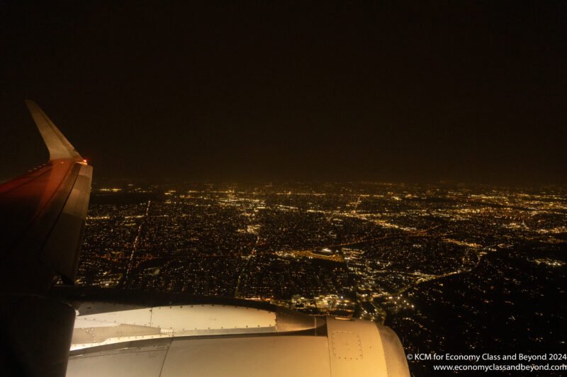 an airplane wing over a city at night