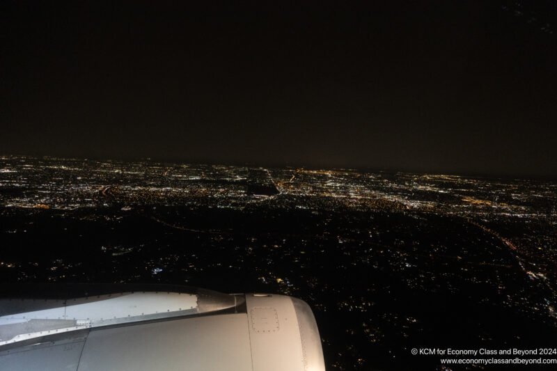 an airplane wing and a city at night