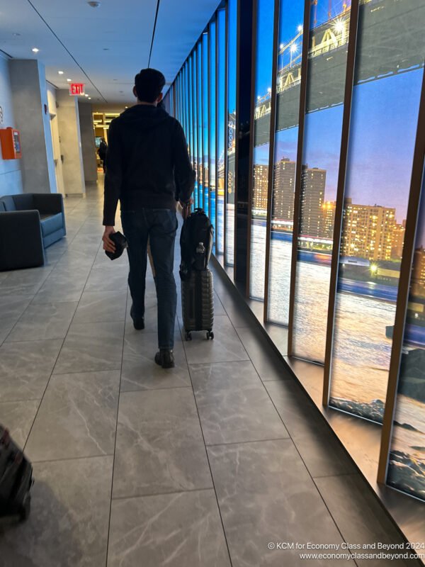 a man walking with luggage in a hallway