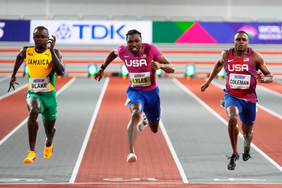 gold medalist Christian Coleman, of the United States, Silver medalist Noah Lyles, of the United States, and bronze medalist Ackeem Blake, of Jamaica, from right, cross the finish line in the men's 60 meters final during the World Athletics Indoor Championships at the Emirates Arena in Glasgow, Scotland, Friday, March 1, 2024. (AP Photo/Petr David Josek)