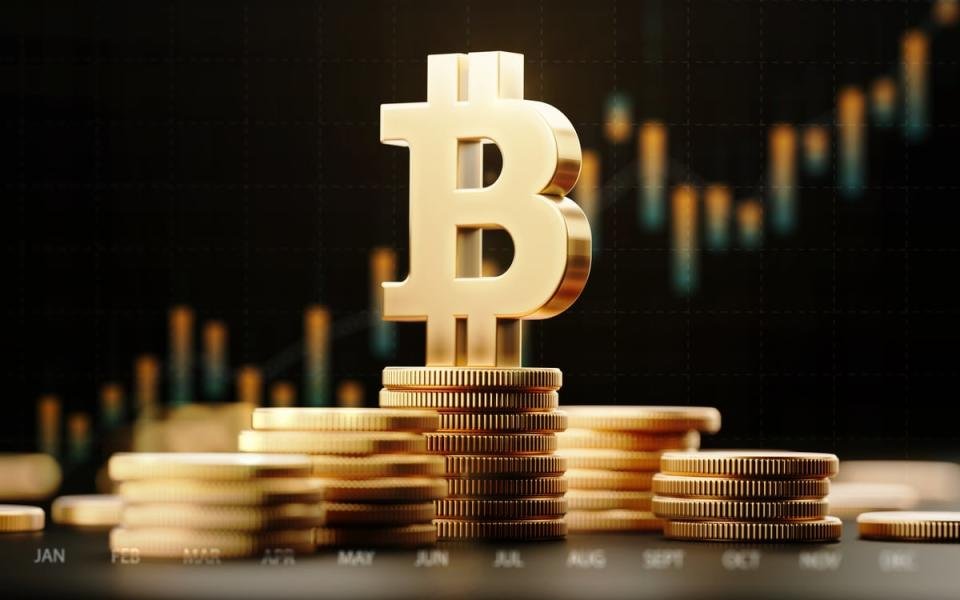 A graphic showing the Bitcoin symbol sitting on top of a pile of coins with a price chart in the background.