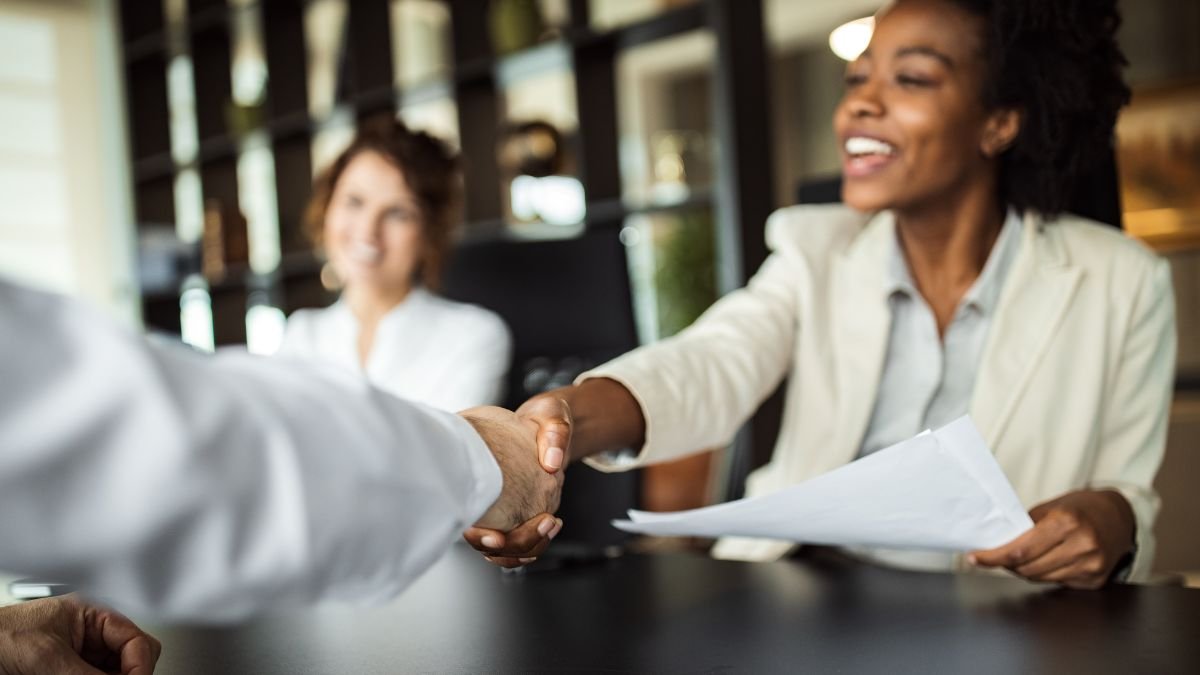 Black woman shakes hands with white recruiter after getting a job