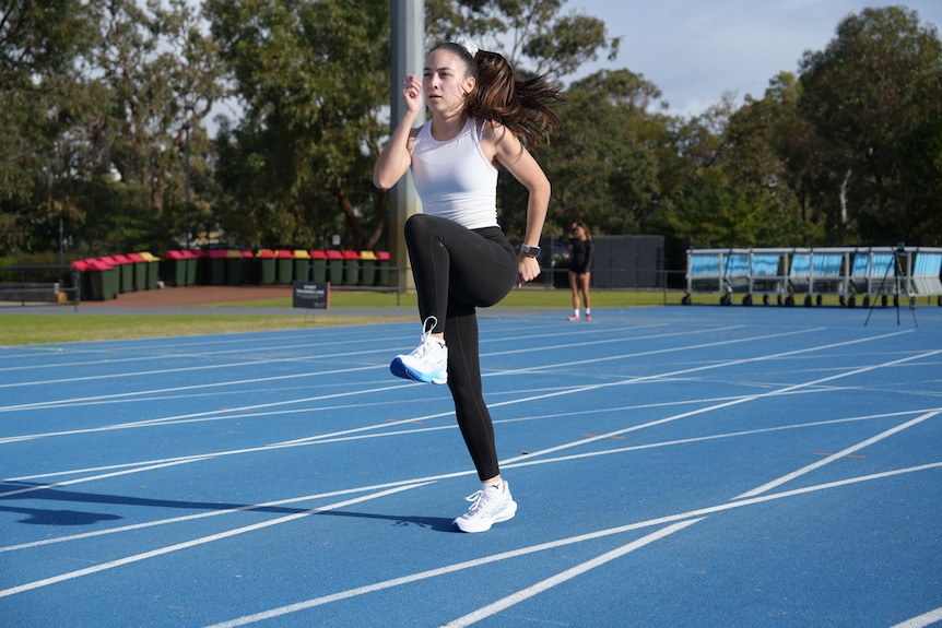 Rhiannon Clarke, WAIS athlete and paralympian, poses in the WAIS indoor running track