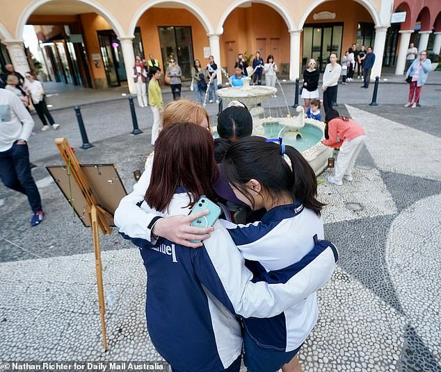 Emerald Lakes locals console each other at a vigil for Sophie Wang held on Friday