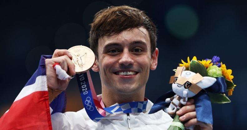 Tom Daley holds his medal