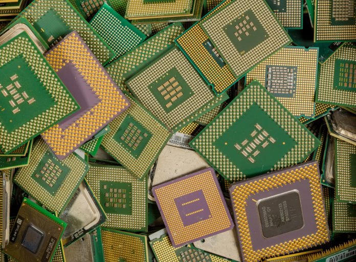 An assorted pile of obsolete computer CPUs for recycling. The CPUs have gold plated pins.