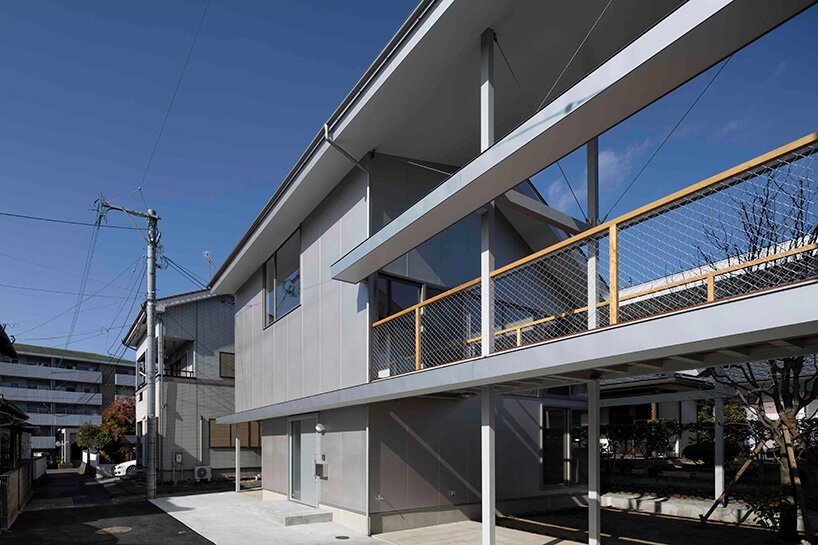 silver panels mirror japanese cityscape on goya schröder’s wooden-framed residence