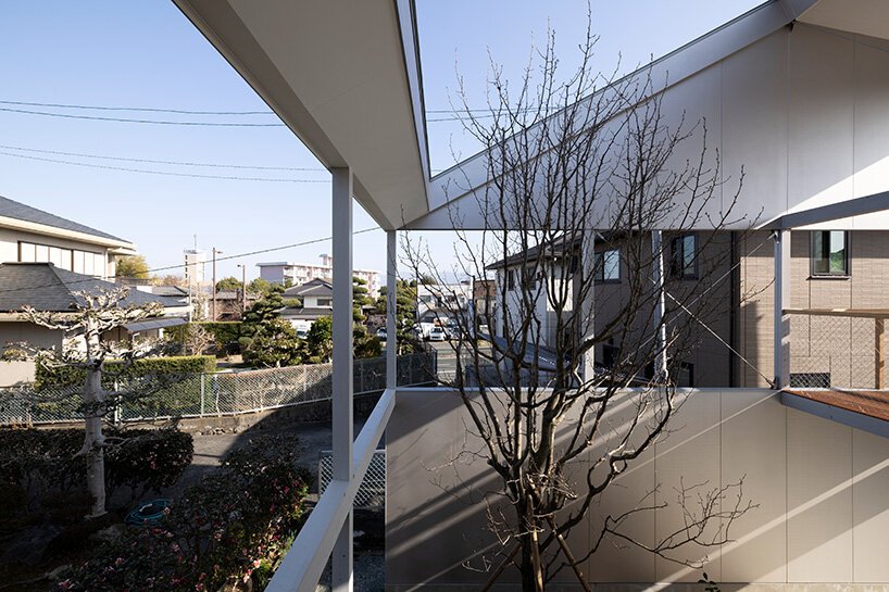 silver panels mirror japanese cityscape on goya schröder’s wooden-framed residence