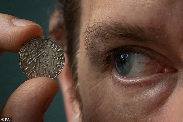 Ian Richardson, Treasure Registrar at the British Museum holding a rare example of a mule, a coin from the time of Edward the Confessor (1042-66)