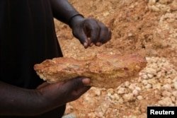 An illegal artisanal miner inspects an excavated rock for traces of gold at the Prestea-Huni Valley Municipal District in the Western Region, Ghana August 17, 2024. (REUTERS/Francis Kokoroko)