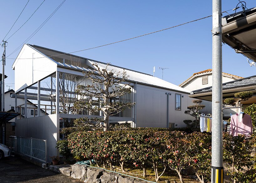 silver panels mirror japanese cityscape on goya schröder’s wooden-framed residence